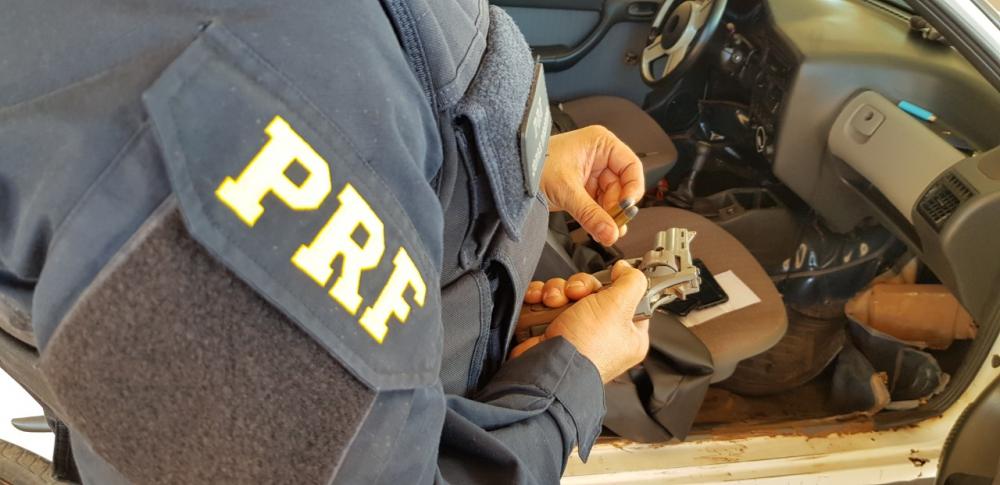 Arma apreendida foi encontrada debaixo do banco do carro — Foto: Divulgação/PRF